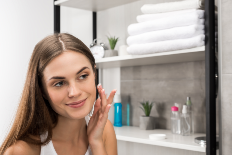 beautiful-woman-with-clear-skin-applying-cream